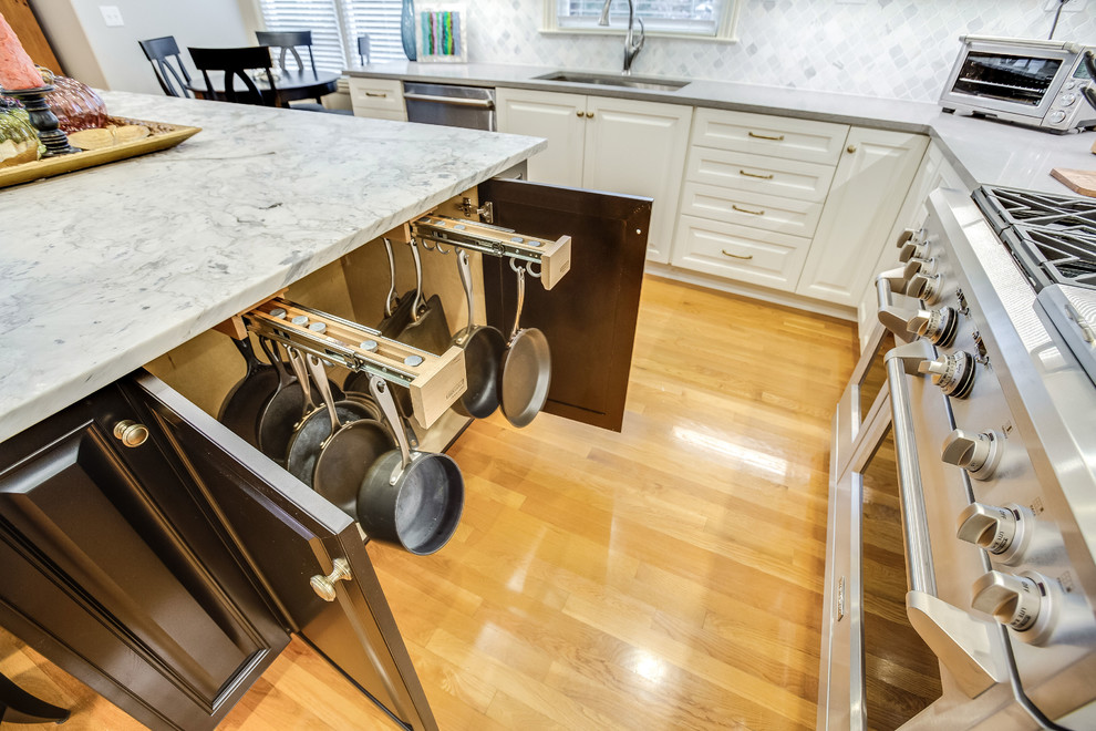 Inspiration for a large transitional u-shaped light wood floor and yellow floor open concept kitchen remodel in Birmingham with raised-panel cabinets, white cabinets, marble countertops, white backsplash, marble backsplash, stainless steel appliances, an island and white countertops