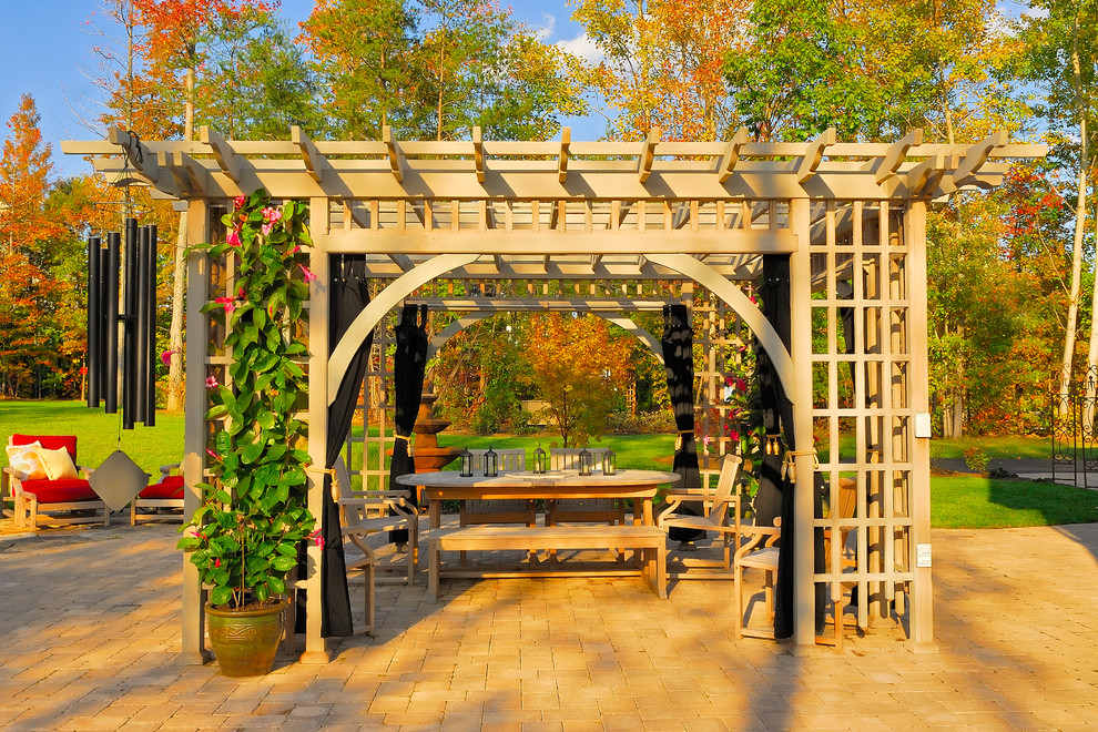 Inspiration for an expansive traditional backyard patio in Baltimore with a pergola and natural stone pavers.