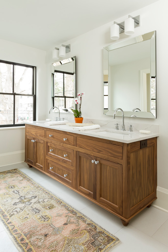 Large transitional master bathroom in Minneapolis with shaker cabinets, medium wood cabinets, white tile, ceramic tile, white walls, porcelain floors, an undermount sink, engineered quartz benchtops, white floor and a hinged shower door.