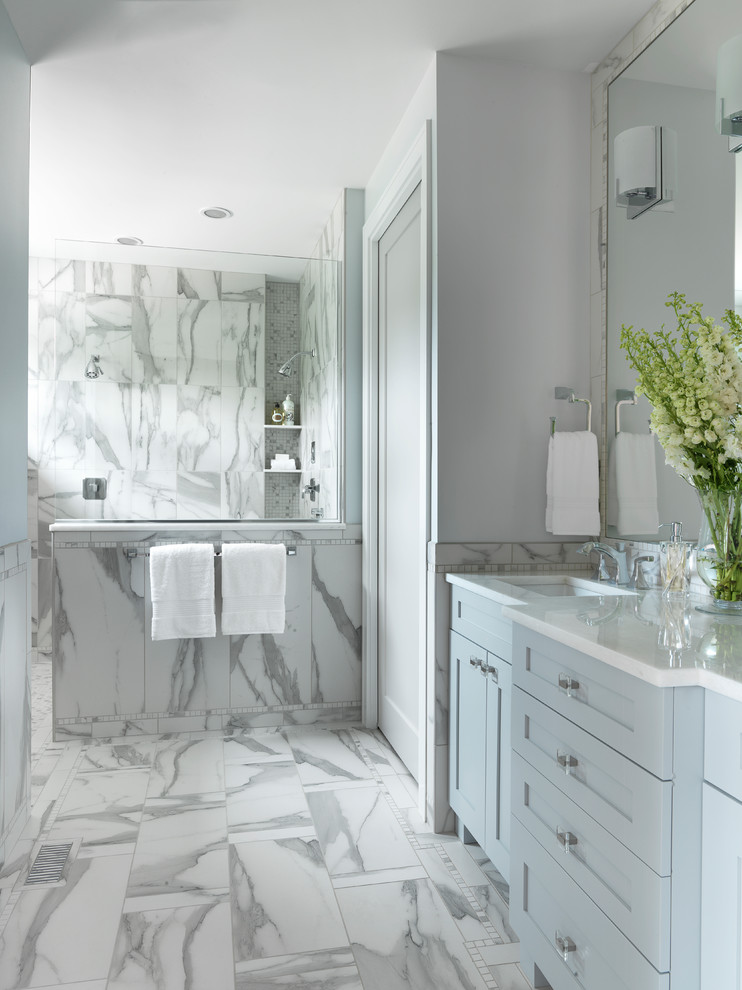 Walk-in shower - large transitional master porcelain tile porcelain tile and white floor walk-in shower idea in St Louis with shaker cabinets, blue cabinets, white walls, an undermount sink and solid surface countertops