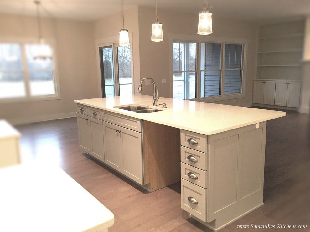 Eat-in kitchen - mid-sized transitional l-shaped medium tone wood floor eat-in kitchen idea with an undermount sink, shaker cabinets, gray cabinets, quartz countertops, white backsplash, subway tile backsplash and an island