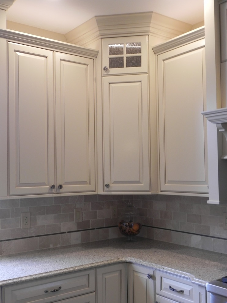Mid-sized transitional kitchen photo with raised-panel cabinets, white cabinets, beige backsplash, subway tile backsplash and stainless steel appliances