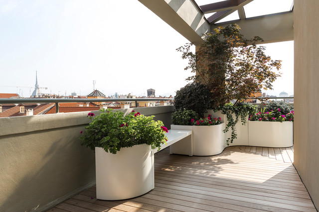 Terrazzo importante con pavimento in teak, fioriere perimetrali e arredi contemporary-deck