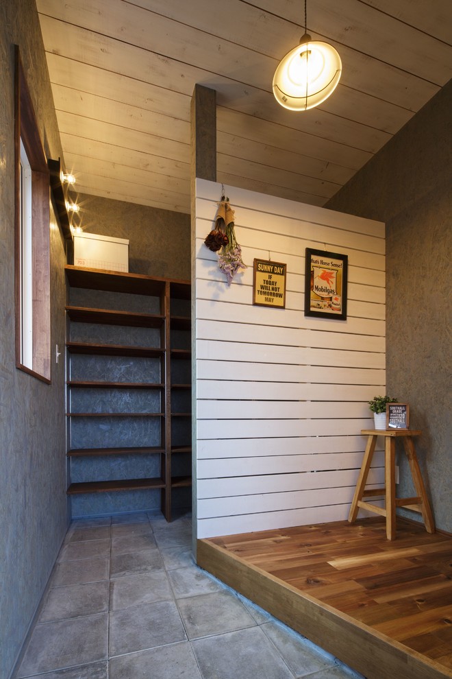 Photo of a beach style entryway in Other with grey walls and grey floor.