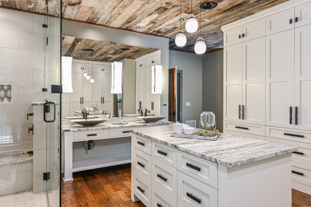 Design ideas for a large country master bathroom in Other with white cabinets, grey walls, recessed-panel cabinets, white tile, medium hardwood floors, a vessel sink, a hinged shower door and multi-coloured benchtops.