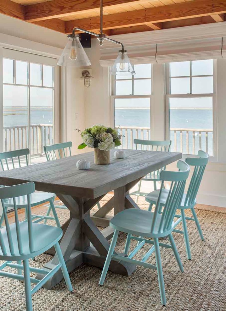 Inspiration for a mid-sized beach style dining room in Boston with white walls and light hardwood floors.