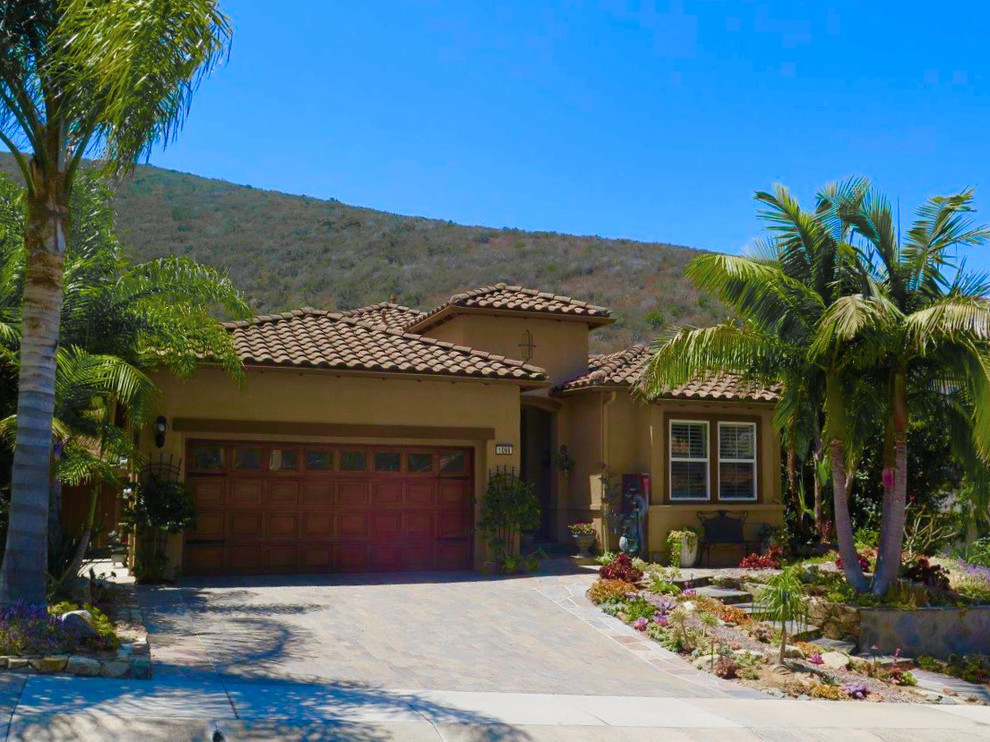 Design ideas for a mid-sized mediterranean partial sun front yard stone driveway in San Diego.