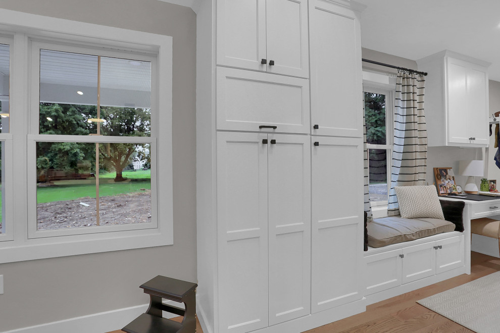Example of a mid-sized transitional l-shaped open concept kitchen design with flat-panel cabinets, white cabinets, quartz countertops, gray backsplash, an island and white countertops