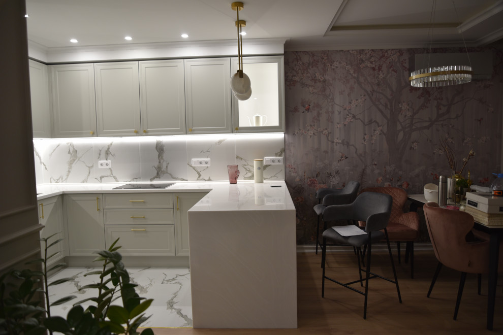 Large traditional grey and white l-shaped kitchen/diner in Moscow with a submerged sink, recessed-panel cabinets, grey cabinets, composite countertops, white splashback, porcelain splashback, black appliances, porcelain flooring, a breakfast bar, white floors, white worktops and a drop ceiling.