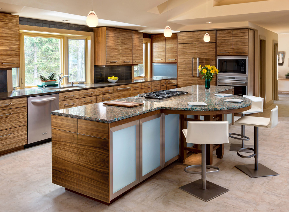 This is an example of a contemporary l-shaped kitchen in Milwaukee with an undermount sink, flat-panel cabinets, medium wood cabinets, recycled glass benchtops, black splashback, ceramic splashback, stainless steel appliances, linoleum floors and with island.