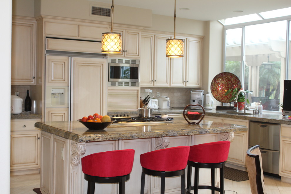 Inspiration for a large transitional u-shaped ceramic tile and beige floor enclosed kitchen remodel in Orange County with an undermount sink, recessed-panel cabinets, beige cabinets, granite countertops, beige backsplash, stone tile backsplash, stainless steel appliances, an island and beige countertops