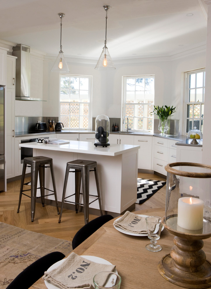Inspiration for a mid-sized transitional u-shaped open plan kitchen in Adelaide with flat-panel cabinets, white cabinets, medium hardwood floors and with island.