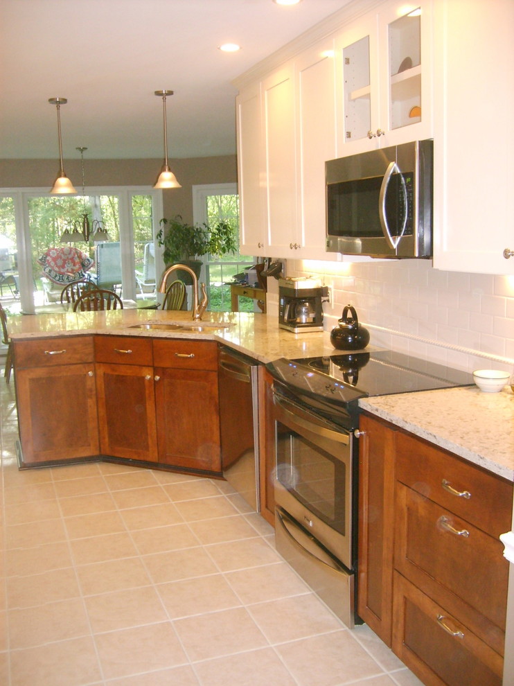 Eat-in kitchen - transitional galley eat-in kitchen idea with an undermount sink, shaker cabinets, dark wood cabinets, quartz countertops, white backsplash, subway tile backsplash and stainless steel appliances