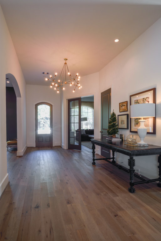 Foyer - mid-sized transitional light wood floor foyer idea in Houston with white walls and a dark wood front door
