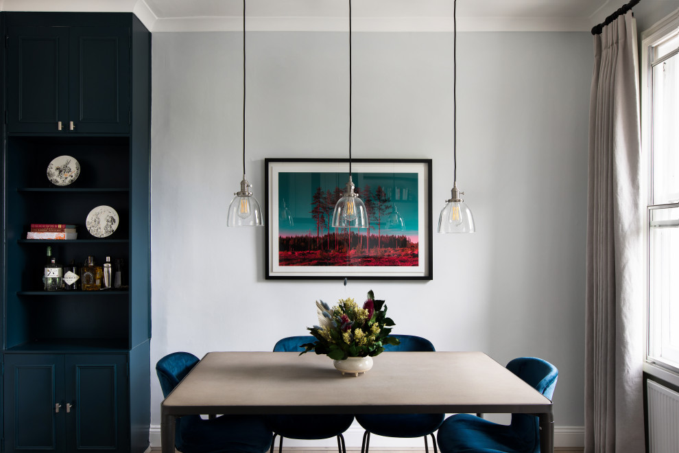 Источник вдохновения для домашнего уюта: отдельная столовая среднего размера в современном стиле с синими стенами, паркетным полом среднего тона, стандартным камином, фасадом камина из штукатурки и серым полом