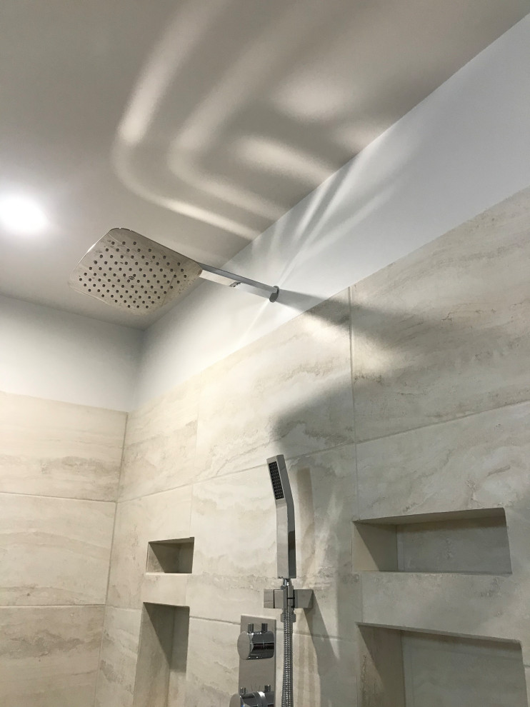 Example of a large transitional master beige tile and ceramic tile corner shower design with beige walls