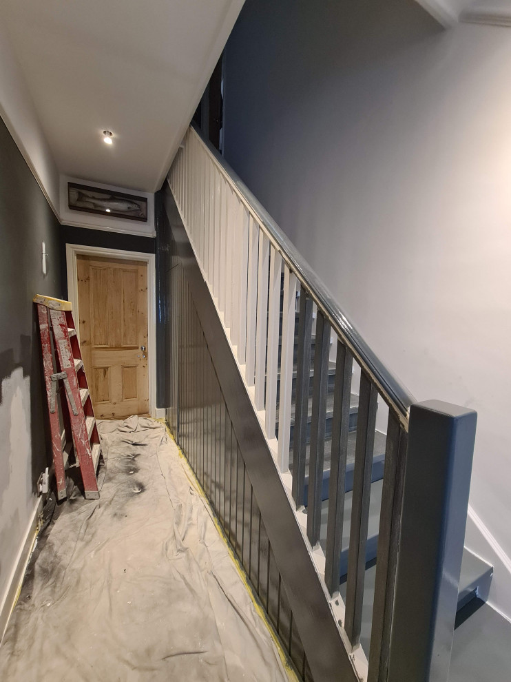 Esempio di un ampio ingresso o corridoio chic con pareti bianche, pavimento in legno verniciato, pavimento nero e soffitto ribassato
