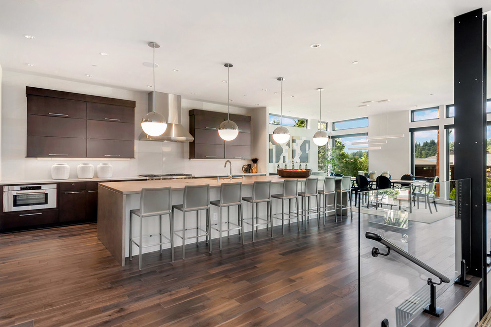 Inspiration for a large contemporary eat-in kitchen in Seattle with an undermount sink, flat-panel cabinets, dark wood cabinets, concrete benchtops, white splashback, stainless steel appliances, dark hardwood floors, with island, brown floor and glass sheet splashback.