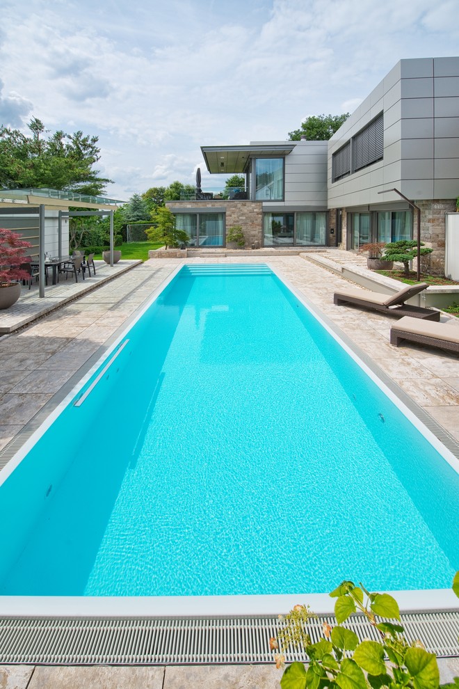 Oberirdischer, Großer Moderner Pool hinter dem Haus in rechteckiger Form mit Natursteinplatten in Frankfurt am Main