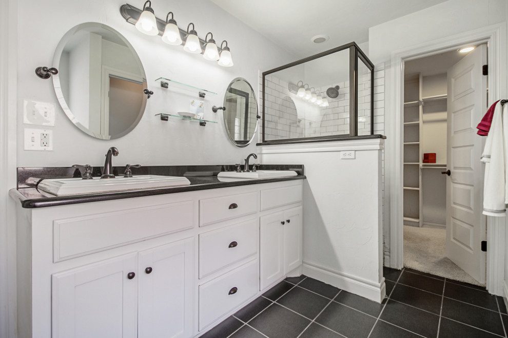 Photo of a small country 3/4 bathroom in Atlanta with white cabinets, a two-piece toilet, white tile, ceramic tile, white walls, cement tiles, a drop-in sink, a hinged shower door, black benchtops, a double vanity, a built-in vanity and recessed-panel cabinets.