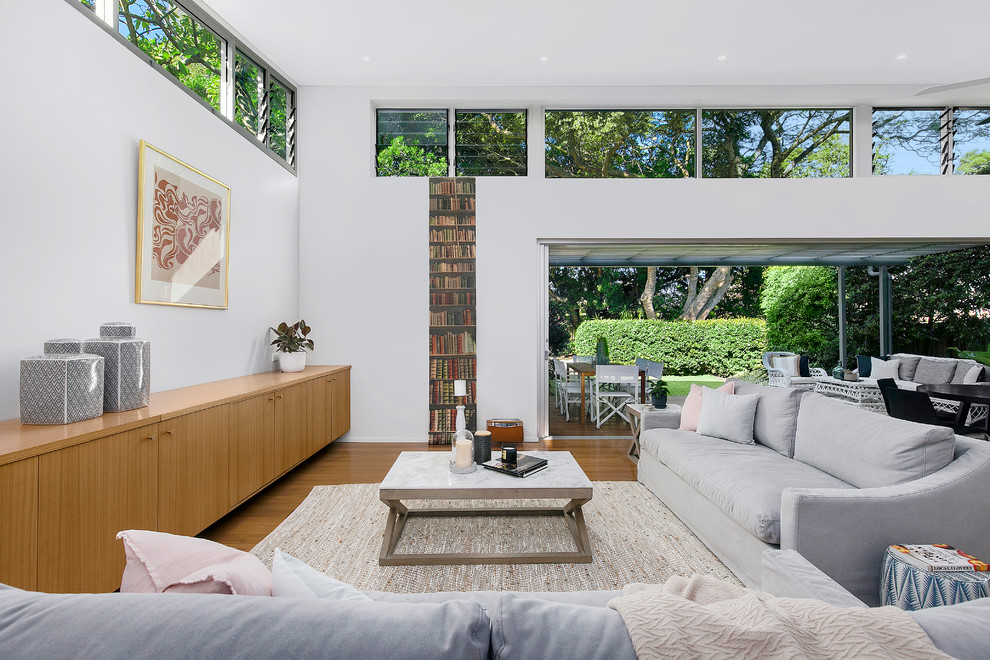 Photo of a mid-sized contemporary formal open concept living room in Sydney with medium hardwood floors, white walls and brown floor.