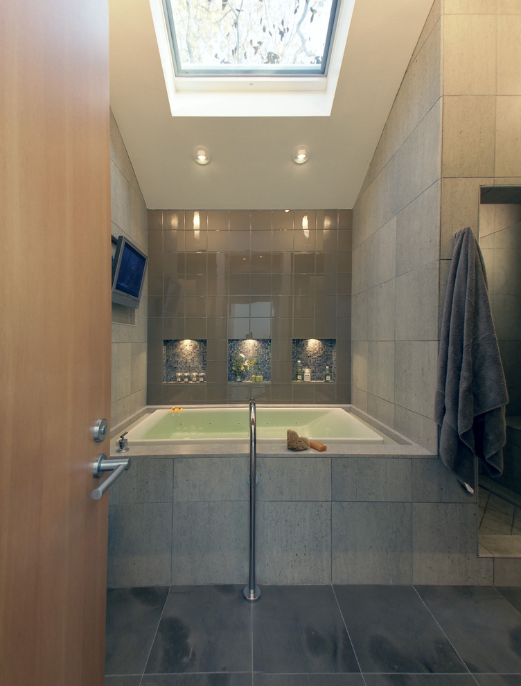 Inspiration for a mid-sized modern master bathroom in San Francisco with flat-panel cabinets, light wood cabinets, a freestanding tub, an open shower, a two-piece toilet, gray tile, cement tile, grey walls, cement tiles, an integrated sink, concrete benchtops, grey floor and a hinged shower door.