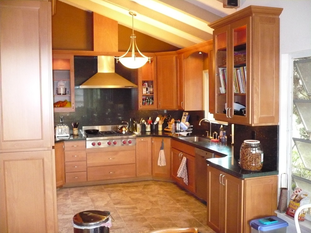 This is an example of a small country u-shaped kitchen pantry in Hawaii with an undermount sink, shaker cabinets, medium wood cabinets, black splashback, stone slab splashback, stainless steel appliances, slate floors, no island and beige floor.