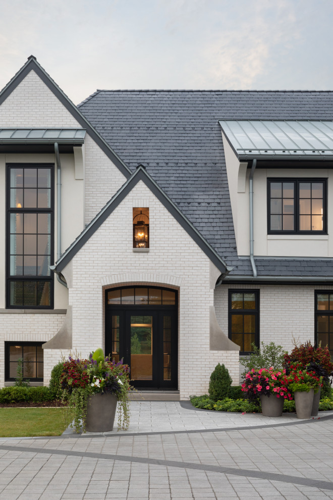 Diseño de fachada de casa blanca y negra campestre de dos plantas con revestimiento de ladrillo y tejado a dos aguas