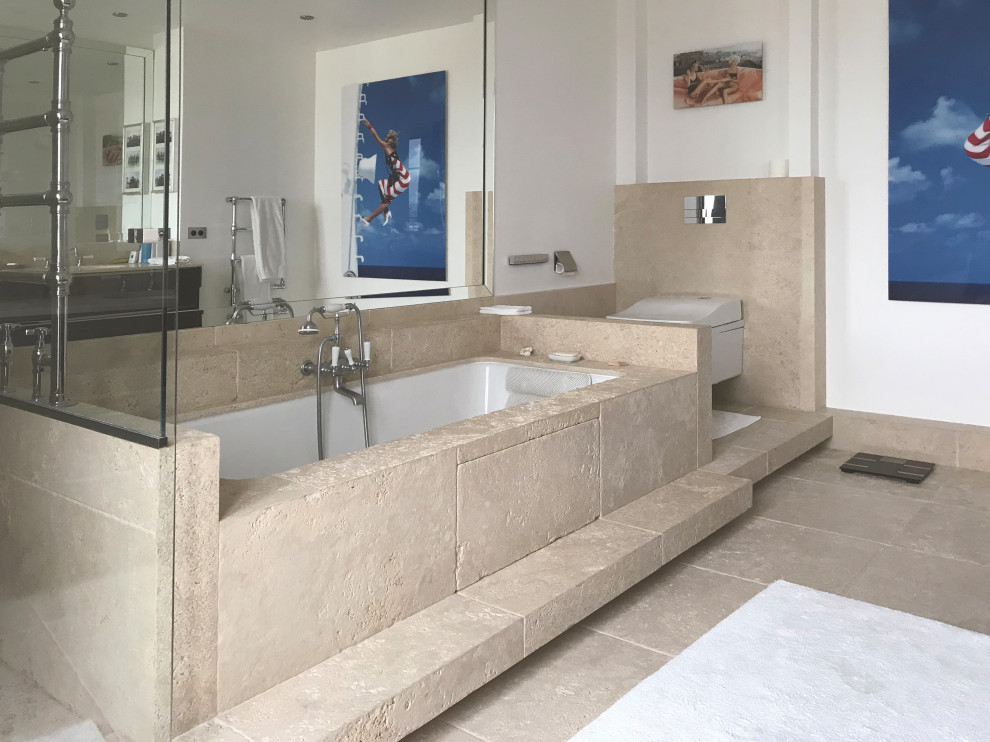 Photo of a large modern master bathroom in Paris with beaded inset cabinets, brown cabinets, an undermount tub, an alcove shower, a wall-mount toilet, beige tile, travertine, white walls, travertine floors, an undermount sink, limestone benchtops, beige floor, a hinged shower door, beige benchtops, a shower seat, a double vanity, a freestanding vanity and recessed.