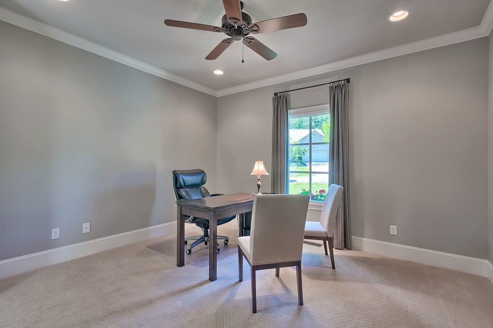 This is an example of a mid-sized transitional study room in Other with grey walls, carpet, no fireplace and a freestanding desk.