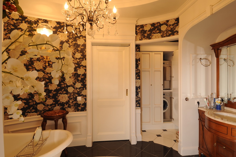 Источник вдохновения для домашнего уюта: главная ванная комната среднего размера в классическом стиле с фасадами с утопленной филенкой, коричневыми фасадами, ванной на ножках, бежевой плиткой, плиткой из листового камня, черными стенами, полом из керамогранита, мраморной столешницей, черным полом, бежевой столешницей, тумбой под одну раковину, напольной тумбой, многоуровневым потолком и обоями на стенах