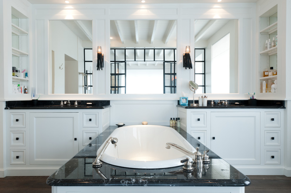 This is an example of a large transitional master bathroom in Paris with marble benchtops, an undermount tub, white walls, dark hardwood floors and an integrated sink.