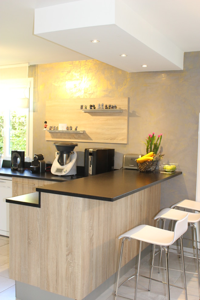 This is an example of a contemporary kitchen in Other with granite benchtops and black splashback.