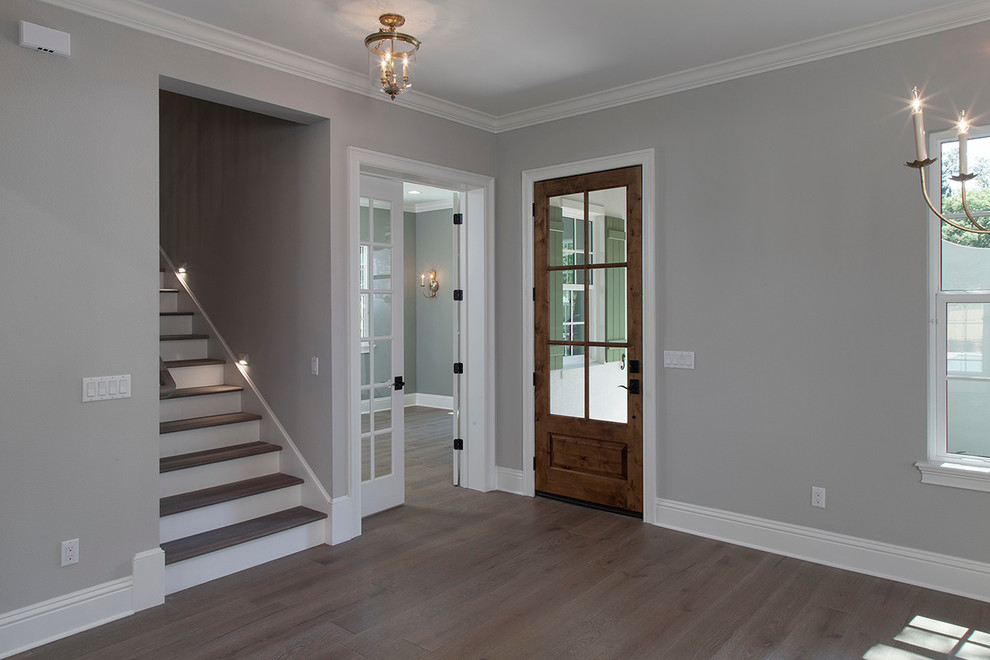Front door - mid-sized transitional light wood floor front door idea in Orlando with gray walls and a dark wood front door