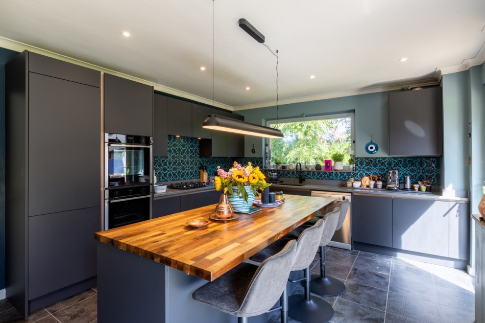 Design ideas for a medium sized contemporary l-shaped kitchen/diner in Sussex with flat-panel cabinets, grey cabinets, quartz worktops, multi-coloured splashback, ceramic splashback, an island and grey worktops.