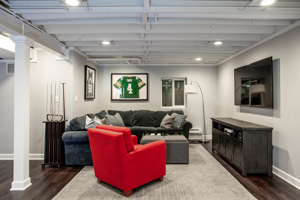 Inspiration for a large transitional fully buried basement in Chicago with a game room, grey walls, vinyl floors, brown floor and exposed beam.
