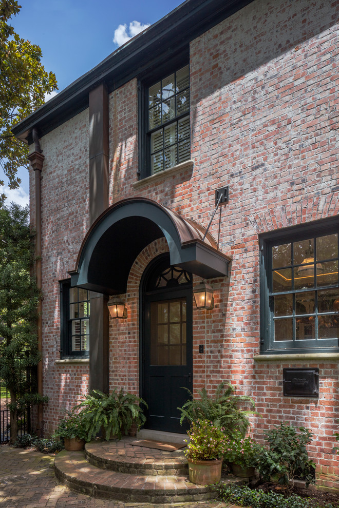 Design ideas for a mid-sized traditional two-storey brick exterior in Houston with a hip roof.