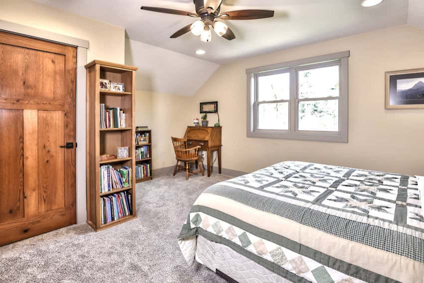 Country guest bedroom in Other with beige walls, carpet and grey floor.