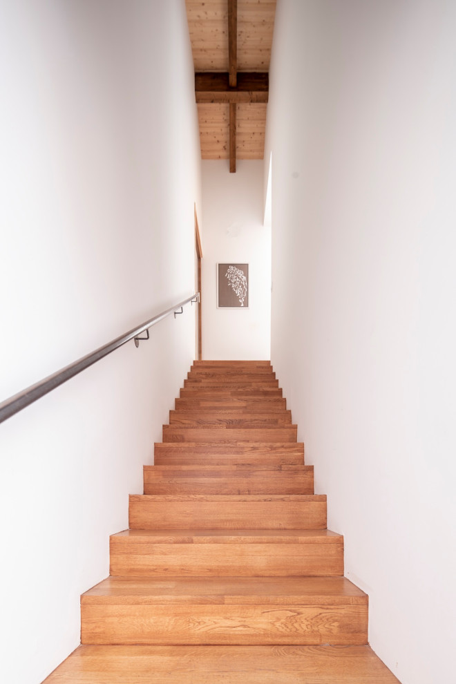 Modelo de escalera recta nórdica de tamaño medio con escalones de madera, contrahuellas de madera, barandilla de metal y papel pintado