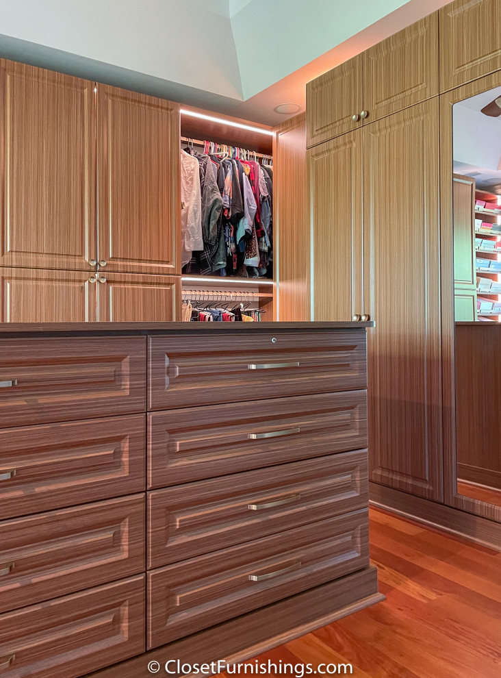 Inspiration for a large traditional walk-in wardrobe for women in Chicago with raised-panel cabinets and brown cabinets.