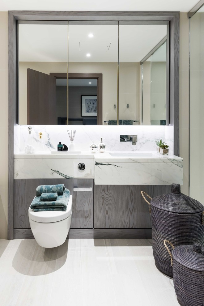 This is an example of a mid-sized contemporary 3/4 bathroom in London with flat-panel cabinets, dark wood cabinets, white tile, an integrated sink, beige floor, marble and marble benchtops.