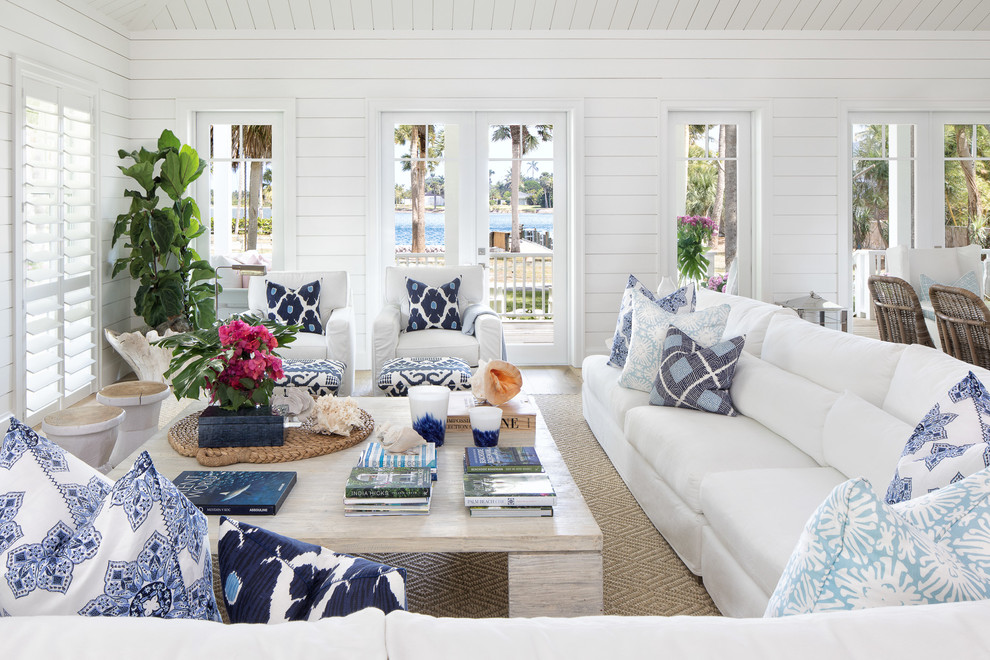 Photo of a beach style living room in Miami with white walls, medium hardwood floors and brown floor.