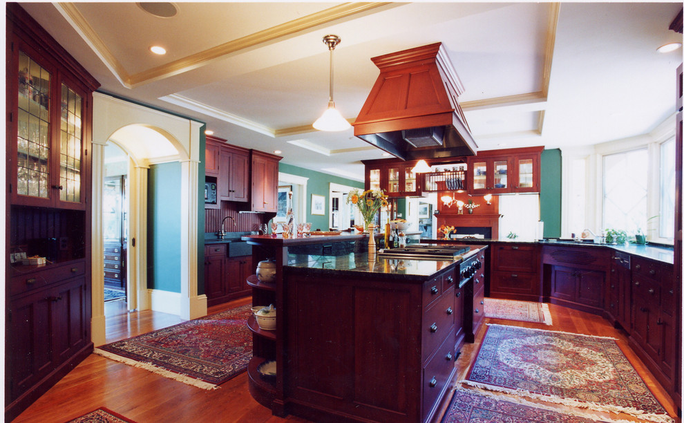 Inspiration for an expansive traditional u-shaped open plan kitchen in Boston with a farmhouse sink, recessed-panel cabinets, dark wood cabinets, granite benchtops, green splashback, stainless steel appliances and medium hardwood floors.