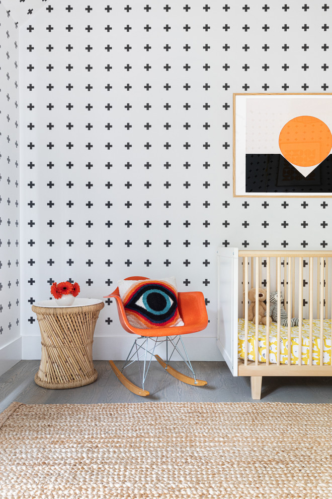 This is an example of a large beach style nursery for boys in New York with dark hardwood floors and grey floor.