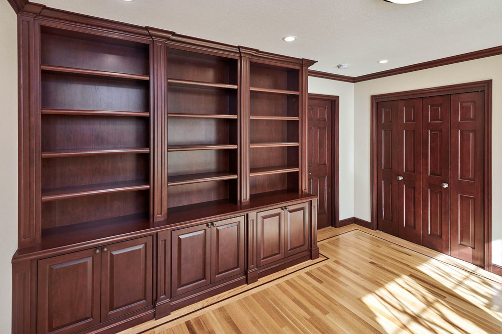 Traditional home office in San Francisco with a library, beige walls, medium hardwood floors and a freestanding desk.