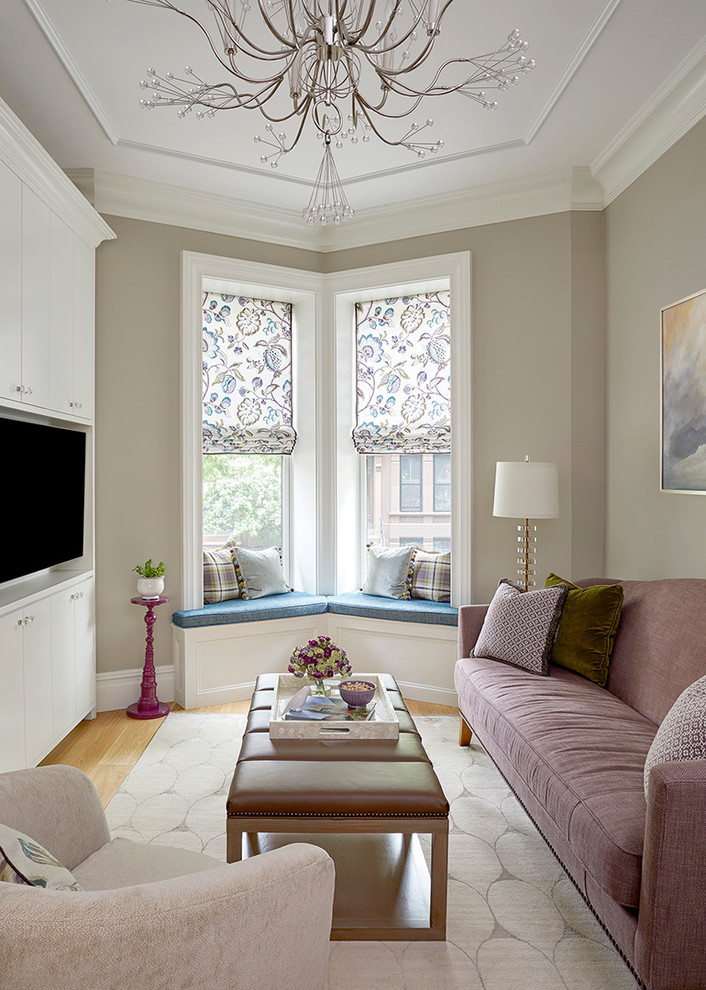 This is an example of a small transitional enclosed family room in New York with a built-in media wall, grey walls, no fireplace, light hardwood floors and beige floor.