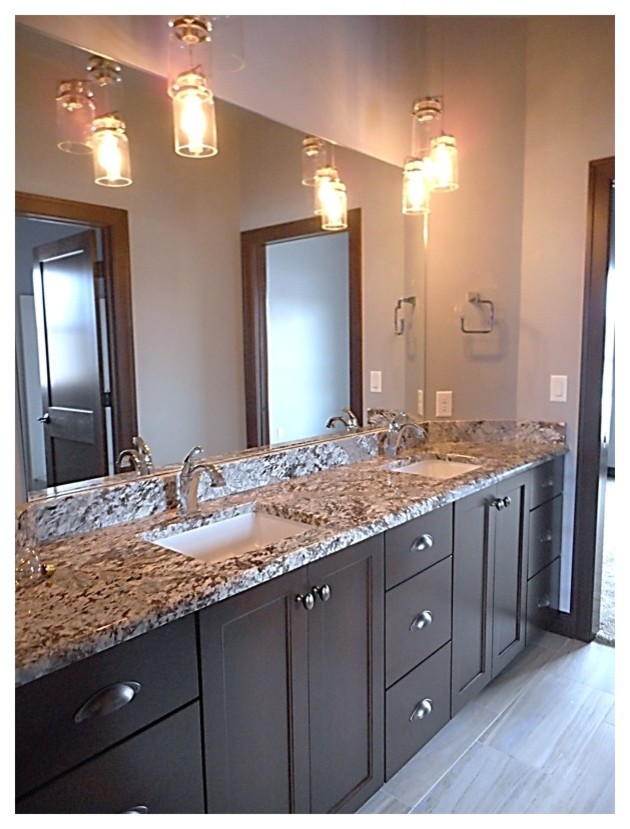 This is an example of a large contemporary master bathroom in Milwaukee with shaker cabinets, brown cabinets, grey walls, porcelain floors, an undermount sink and granite benchtops.