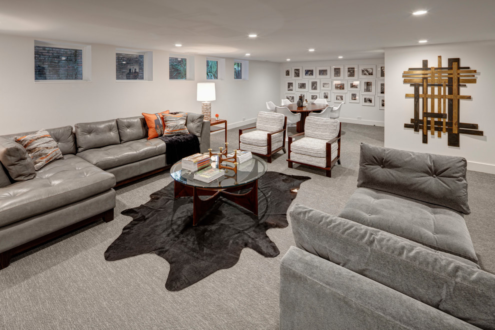 Photo of a large midcentury look-out basement in Detroit with white walls, carpet, no fireplace and grey floor.