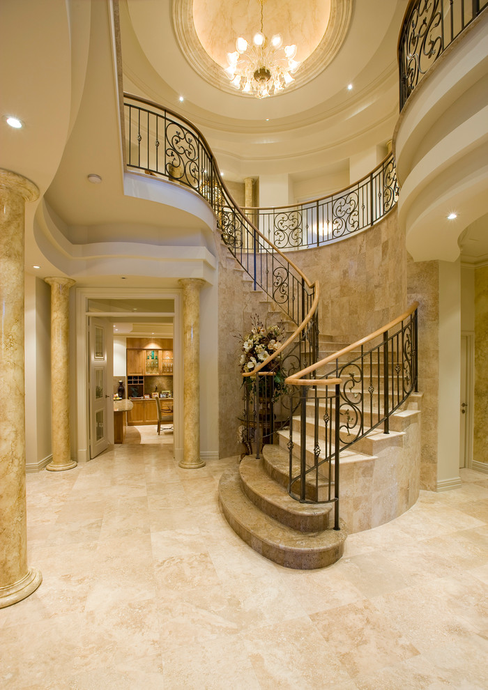 Large mediterranean travertine curved staircase in Perth with travertine risers, mixed railing and decorative wall panelling.