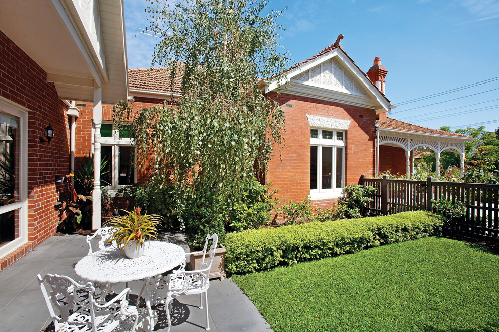 Design ideas for a traditional courtyard formal garden in Melbourne with natural stone pavers.